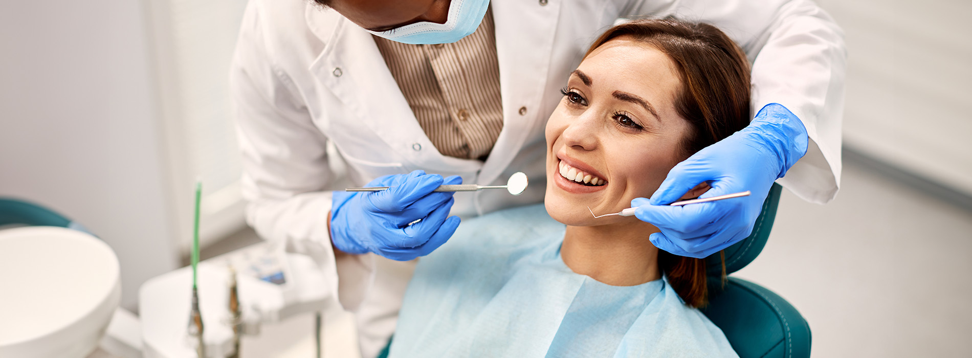 A woman receiving dental treatment with a dentist performing the procedure.
