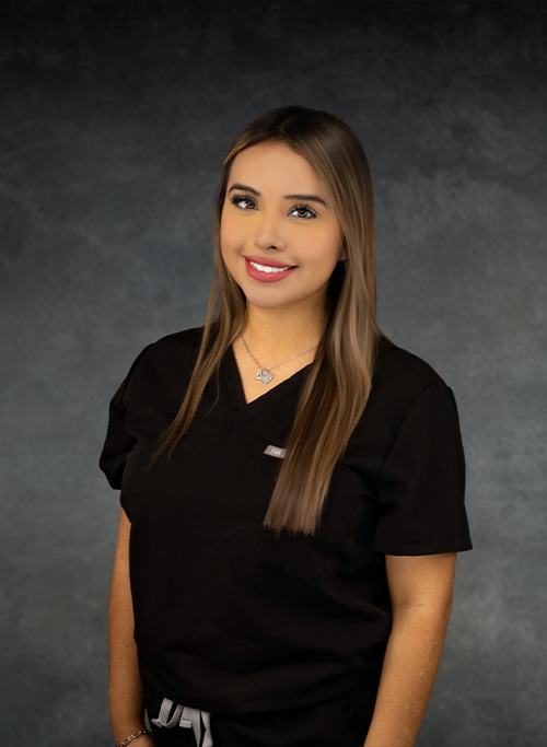The image shows a woman wearing a black scrub top, posing with a slight smile for the camera.